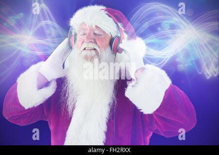 Zusammengesetztes Bild des Weihnachtsmannes genießt einige Musik Stockfoto