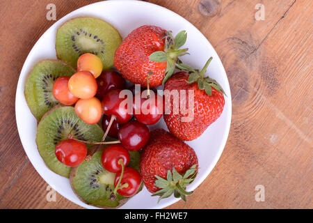 Gesundheit-Frucht mit Kirsche, Erdbeere, Kiwi auf Holzplatte Stockfoto