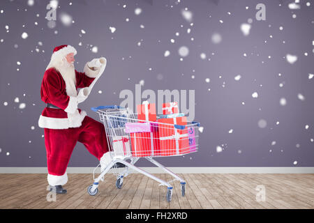 Zusammengesetztes Bild von Santa, die Geschenke aus dem Warenkorb zu liefern Stockfoto