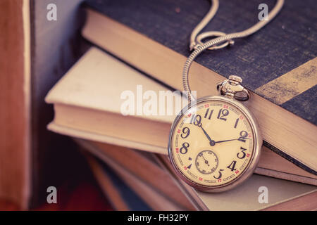 Alte Taschenuhr auf Bücherstapel, Zeit zum Lesen Stockfoto