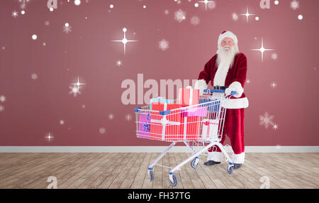 Zusammengesetztes Bild von Santa, die Geschenke aus dem Warenkorb zu liefern Stockfoto