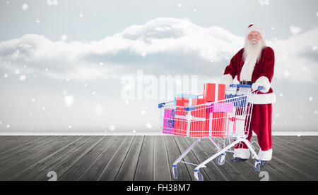 Zusammengesetztes Bild von Santa, die Geschenke aus dem Warenkorb zu liefern Stockfoto