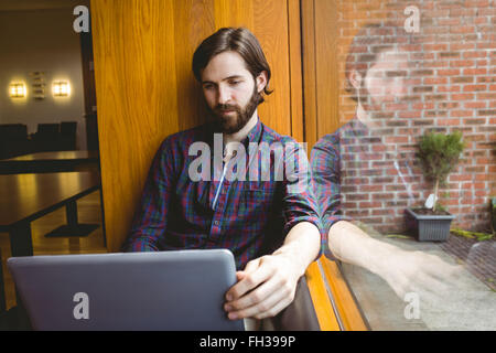 Hipster-Student mit Laptop in Kantine Stockfoto