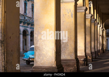 Alte blaue Auto gesehen durch Lücke im sich wiederholendes Muster von Spalten in Havanna, Kuba, Westindische Inseln, Karibik, Mittelamerika Stockfoto