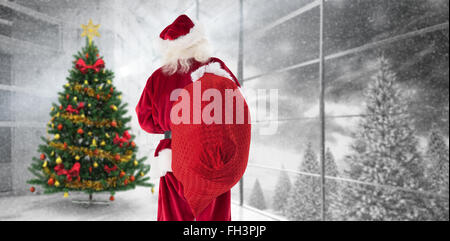 Zusammengesetztes Bild von Santa ist seine Tasche in der Hand halten. Stockfoto