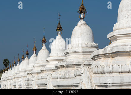 Reihe von weiß getünchten Kyauksa gu Stupas in Kuthodaw Pagode in Mandalay, Birma (Myanmar) Stockfoto