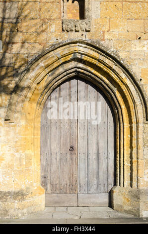 Großer Torbogen und Holztüren am Eingang zum St. James Church in Chipping Campden Stockfoto