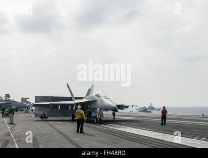 PHILIPPINENSEE (22. Februar 2016) - eine F/A-18E Super Hornet zugeordnet, die Bürgerwehr der Strike Fighter Squadron (VFA) 151 bereitet, von USS John C. Stennis' (CVN-74) starten Flight Deck während japanische Maritime Self-Defense Force Murasume-Klasse Zerstörer JDS Samidare (DD-106) neben dampft. Bereitstellung einer bereit Kraft unterstützende Sicherheit und Stabilität in der Indo-Asien-Pazifik, ist Stennis als Teil der großen grünen Flotte auf einer regelmäßig stattfindenden 7. Flotte Bereitstellung tätig. Stockfoto