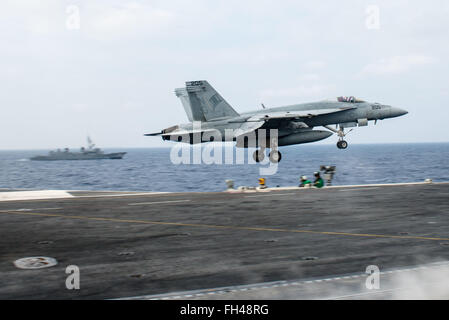 PHILIPPINENSEE (22. Februar 2016) - eine F/A-18E Super Hornet zugeordnet, die Tophatters des Strike Fighter Squadron (VFA) 14 Starts von USS John C. Stennis (CVN-74) flight Deck während japanische Maritime Self-Defense Force Murasume-Klasse Zerstörer JDS Samidare (DD-106) neben dampft. Bereitstellung einer bereit Kraft unterstützende Sicherheit und Stabilität in der Indo-Asien-Pazifik, ist Stennis als Teil der großen grünen Flotte auf einer regelmäßig stattfindenden 7. Flotte Bereitstellung tätig. Stockfoto