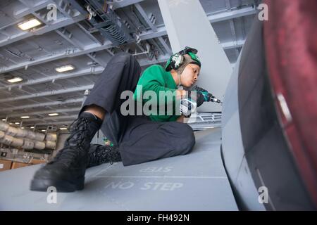 PHILIPPINENSEE (22. Februar 2016) - Aviation strukturelle Mechaniker 3. Klasse Darrick Pierce aus Birmingham, Alabama, führt geplante Wartungsarbeiten an einer F/A-18E Super Hornet der Hangarbucht Warhawks des Strike Fighter Squadron (VFA) 97 in USS John C. Stennis' (CVN-74) zugeordnet. Bereitstellung einer bereit Kraft unterstützende Sicherheit und Stabilität in der Indo-Asien-Pazifik, ist Stennis als Teil der großen grünen Flotte auf einer regelmäßig stattfindenden 7. Flotte Bereitstellung tätig. Stockfoto