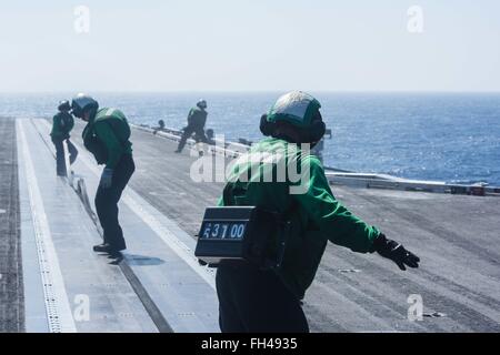 PHILIPPINENSEE (23. Februar 2016) - Segler Silikondichtung einen Schlitz in die Schiene von einem Katapult auf USS John C. Stennis' (CVN-74) Flight Deck nach dem letzten Start eines Start- und Landesystem Zyklus zu verhindern, dass Schmutz fallen. Bereitstellung einer bereit Kraft unterstützende Sicherheit und Stabilität in der Indo-Asien-Pazifik, ist Stennis als Teil der großen grünen Flotte auf einer regelmäßig stattfindenden 7. Flotte Bereitstellung tätig. Stockfoto