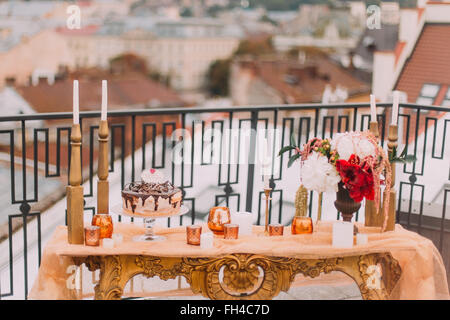 Luxus orientalisch gestalteten goldenen Tisch mit Kerzen und Blumen auf der Terrasse Nahaufnahme Stockfoto
