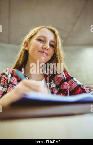 Lächelnde Student Notizen während des Unterrichts Stockfoto