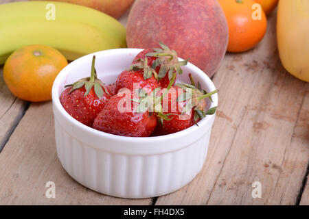 Bananen Apfel Mandarine Pfirsich Erdbeer auf hölzernen Hintergrund als Health Food Konzept Stockfoto