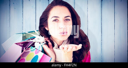 Zusammengesetztes Bild Frau Einkaufstaschen halten und werfen einen Kuss auf den Bildschirm Stockfoto