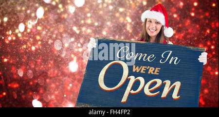 Zusammengesetztes Bild der festlichen Blondine zeigt einen leeren banner Stockfoto