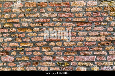 Eine Nahaufnahme, alte Ziegel an der Wand in Venedig. Verschiedene farbige Ziegel können mit alten Zement zwischen ihnen gesehen werden. Stockfoto