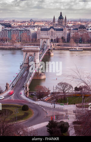 Eine Langzeitbelichtung zeigt Fahrzeuge über Kettenbrücke in Budapest Reisen.  Eine alte gelben Straßenbahn kann in die Rahmen gesehen werden. Stockfoto