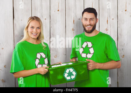 Zusammengesetztes Bild Porträt des Lächelns freiwillige tragen recycling container Stockfoto