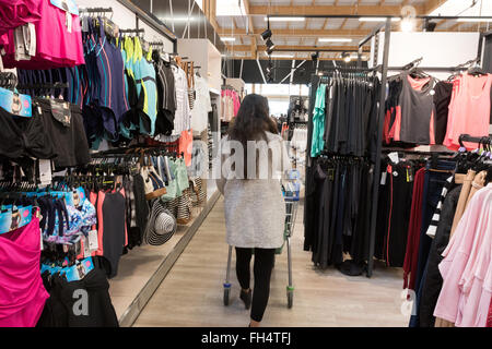 Eine Frau shopping für Kleidung in einem Tesco Extra Supermarkt Laden, Suffolk UK Stockfoto