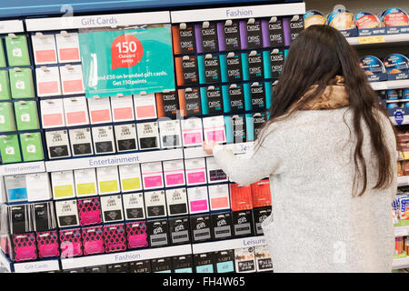 Junge Frau shopping für Store-Geschenkkarten, Tesco Supermarkt Suffolk UK Stockfoto