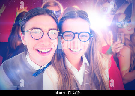 Zusammengesetztes Bild von geeky Hipster lächelnd in die Kamera Stockfoto