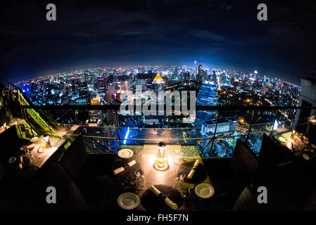 BANGKOK, Thailand – die glitzernde Skyline von Bangkok erstreckt sich unterhalb des Hotels vom Dachrestaurant Vertigo auf dem Dach des Banyan Tree Hotel aus. Wolkenkratzer und Hochhäuser beleuchten die weitläufige thailändische Hauptstadt mit unzähligen Lichtern und schaffen ein atemberaubendes Stadtpanorama. Stockfoto