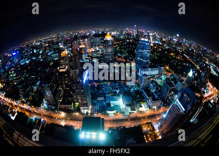 Bangkok Skyline at Night Thailand // BANGKOK, Thailand — die glitzernde Skyline von Bangkok erstreckt sich unterhalb des Hotels vom Restaurant Vertigo auf dem Dach auf dem Banyan Tree Hotel aus. Wolkenkratzer und Hochhäuser beleuchten die weitläufige thailändische Hauptstadt mit unzähligen Lichtern und schaffen ein atemberaubendes Stadtpanorama. Stockfoto