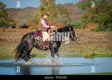 Eine Frau auf einem Pferd im New Forest National Park in Hampshire Stockfoto