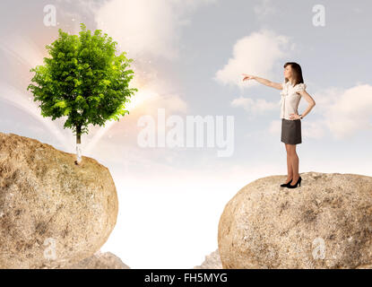 Geschäftsfrau auf Fels-Berg mit einem Baum Stockfoto