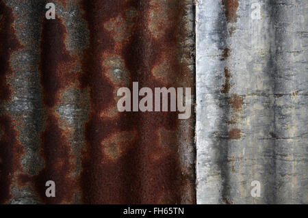 Strukturierte Oberfläche von Wellblech mit kontrastierenden rostige Farben rot und Silber-grau. Detail der alten Wirtschaftsgebäude hautnah. Stockfoto