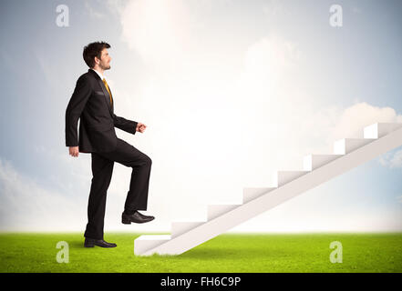 Geschäftsperson klettert auf weiße Treppe in der Natur Stockfoto