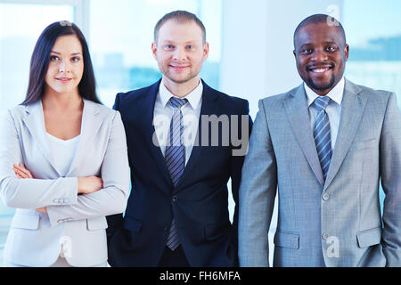 Gruppe von erfolgreichen Managern in Anzügen Blick in die Kamera Stockfoto