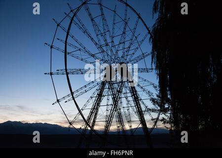 Ein Foto von der Silhouette von einem alten Riesenrad in Toktogul, Kirgisistan. Stockfoto