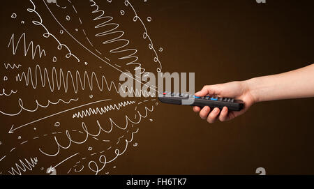 Hand mit Fernbedienung und geschweiften Linien Stockfoto