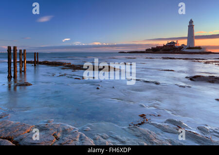 Ebbe auf dem Damm in Richtung St. Marys Leuchtturm, Whitley Bay, England. In der Dämmerung fotografiert. Stockfoto