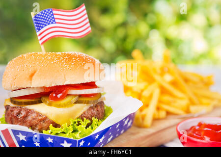 Ein leckerer Burger mit Pommes Frites auf einen Tisch im Freien. Stockfoto