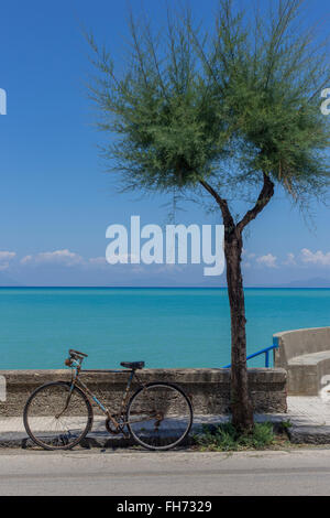 Altes Fahrrad durch Wand neben Baum vor Mittelmeer, Äolischen Inseln Salina, Lipari und Vulcano hinter Stockfoto