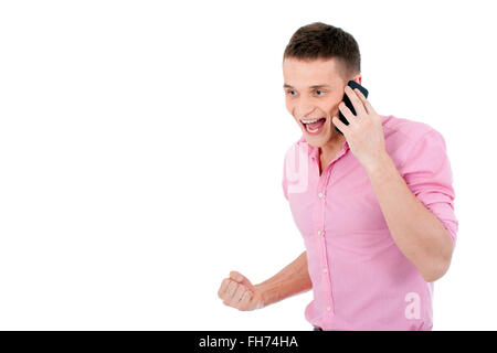 Ein schöner junger Mann am Telefon zu sprechen und eine Erfolg-Geste zum Ausdruck zu bringen. Stockfoto