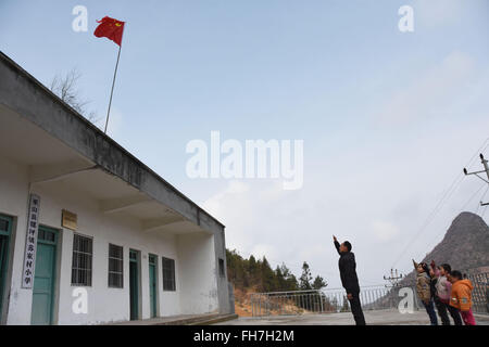 (160224)--CHONGQING, 24. Februar 2016 (Xinhua)--Grundschullehrer Tao Chaolei, 52, und seine vier Studenten, darunter eine in Klasse drei und drei Vorschulalter Kinder, Gruß die Nationalflagge zu Beginn der neuen Amtsperiode am Sujiacun Dorf von Wushan County im Südwesten China Chongqing, 24. Februar 2016.   (Xinhua/Wang Zhonghu) (Dhf) Stockfoto