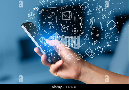 Hand mit Smartphone mit handgezeichneten Media-Icons und Symbole Stockfoto