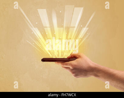 Hand mit Telefon und gelbe Licht Stockfoto