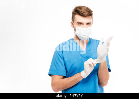 Männlichen Arzt anziehen Handschuhe isoliert auf weißem Hintergrund Stockfoto