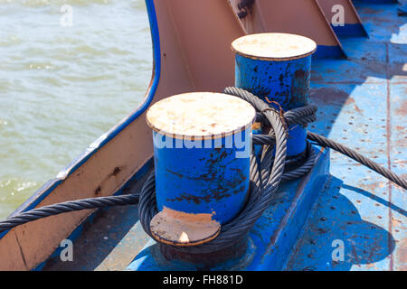 Metallkabeln zusammengerollt auf blauen Anker Poller, Schiff auf hoher See Stockfoto