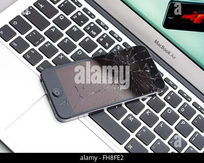 Los Angeles, CA, USA - 7. Dezember 2015: Broken Apple iPhone mit gebrochenen Bildschirm am Laptop Apple MacBook Air Stockfoto