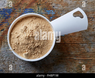 Messbecher von Maca Pulver auf Holztisch, Ansicht von oben Stockfoto