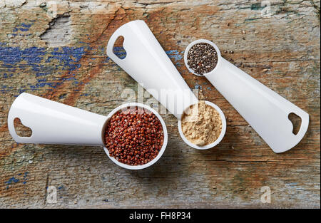 Messenden Kugeln mit rote Quinoa, Maca Pulver und Chia-Samen auf Holztisch, Ansicht von oben Stockfoto