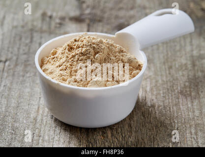 Messbecher von Maca Pulver auf Holztisch Stockfoto