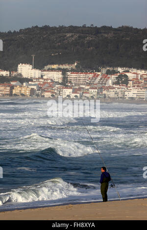 Mann Meeresangeln vom Sandstrand entfernt, Vila Praia de Ancora in Hintergrund, Provinz Minho, Nordportugal Stockfoto