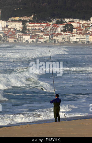 Mann Meeresangeln vom Sandstrand entfernt, Vila Praia de Ancora in Hintergrund, Provinz Minho, Nordportugal Stockfoto